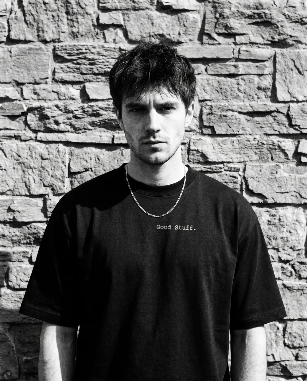 Black and white portrait against a stone wall