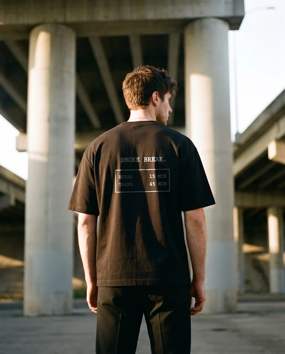 Under a highway overpass, back to the camera