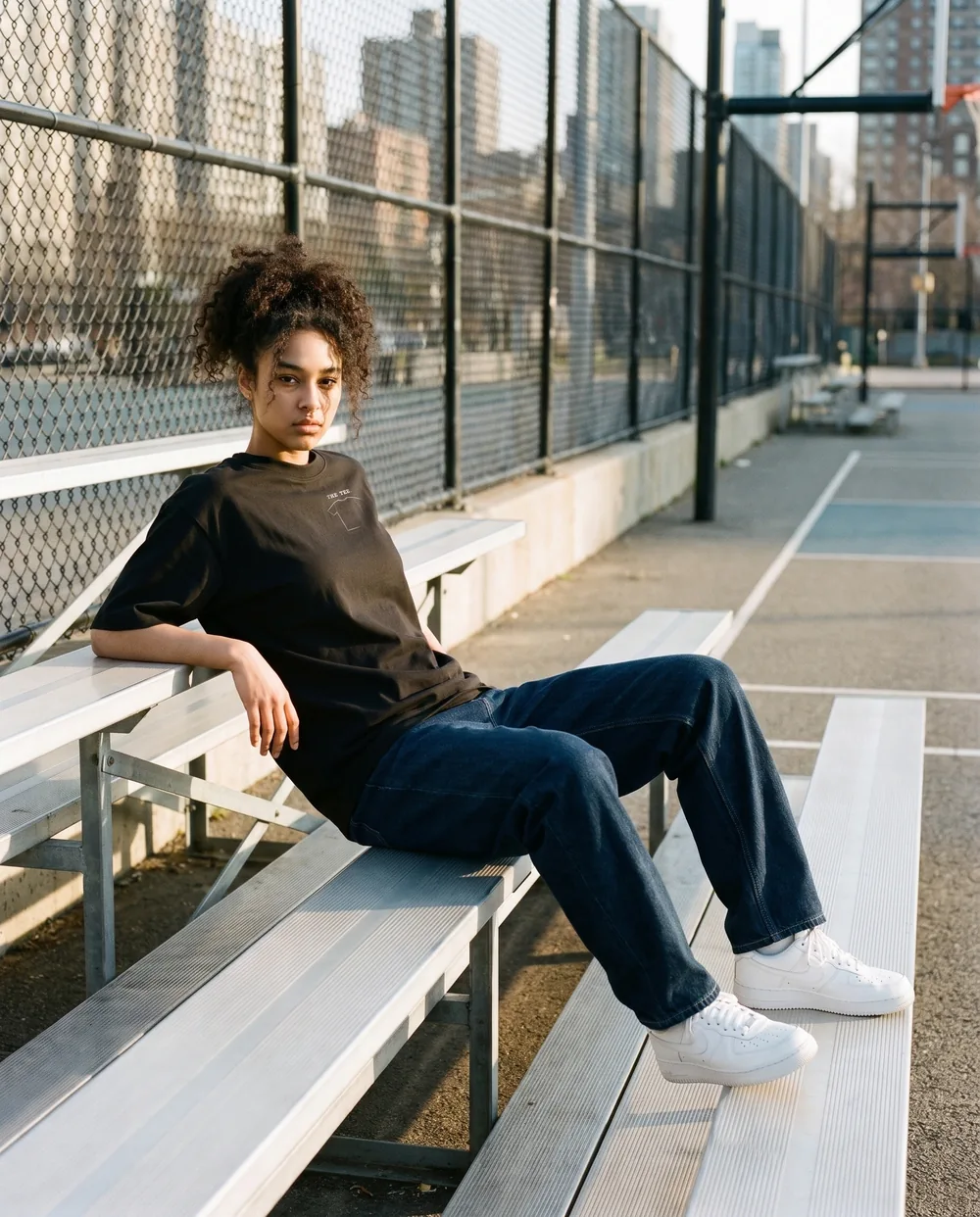 Leaning back on the bleachers by a basketball court