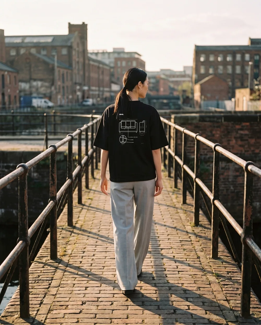 Walking away across a brick canal bridge